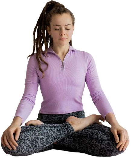 Femme en position de méditation assise, yeux fermés, dans un moment de détente et de relaxation a domicile