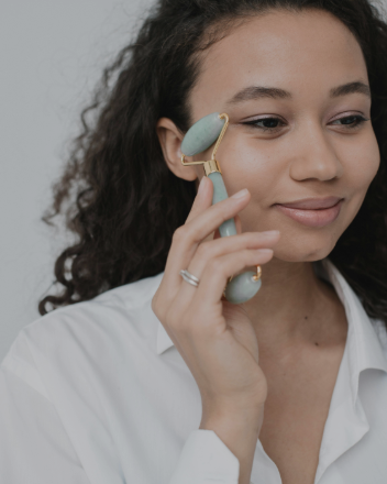 Femme utilisant un rouleau de massage visage pour détendre les muscles et stimuler la circulation